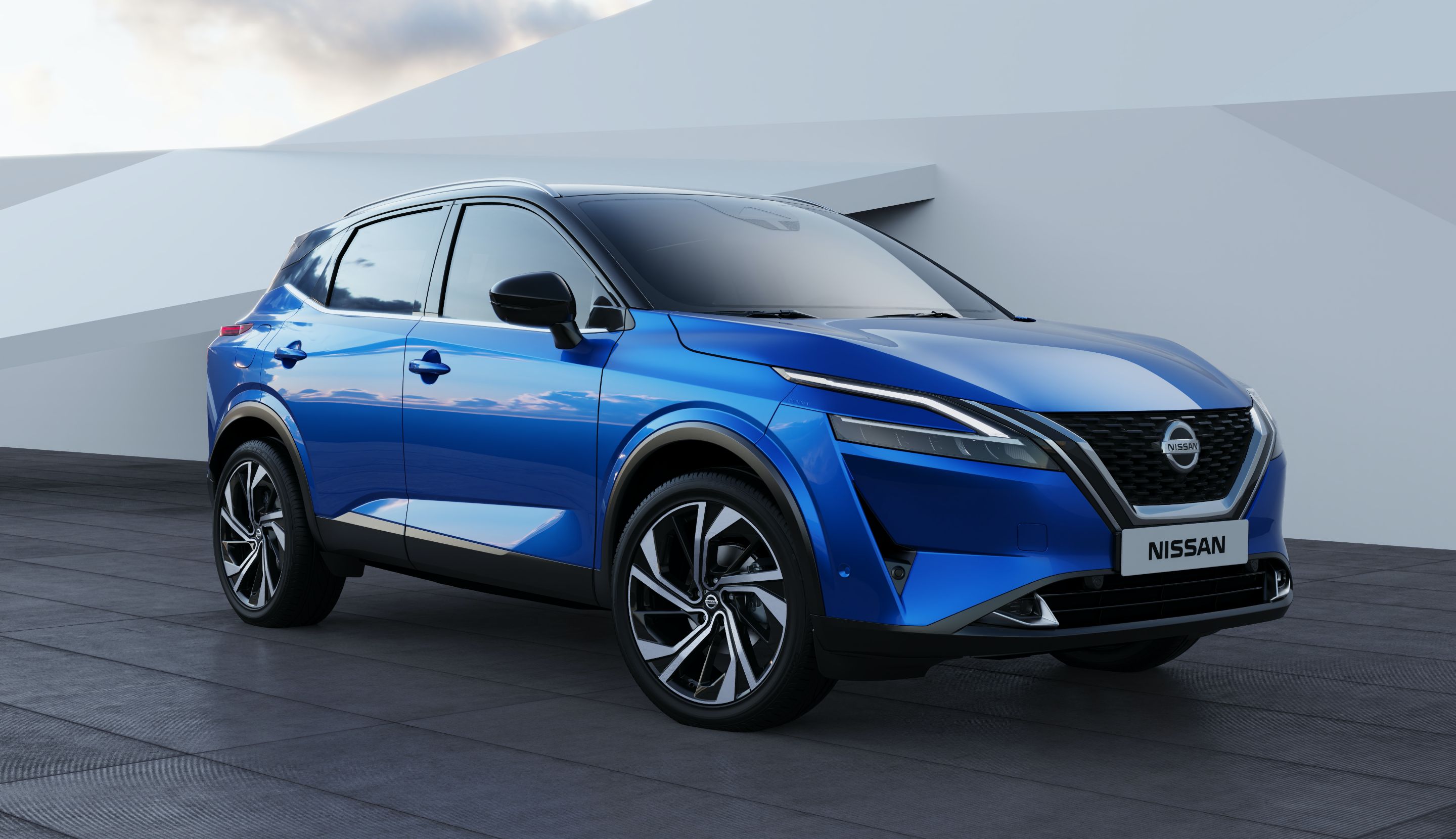 Blue Nissan Qashqai driving beside a dramatic coastline